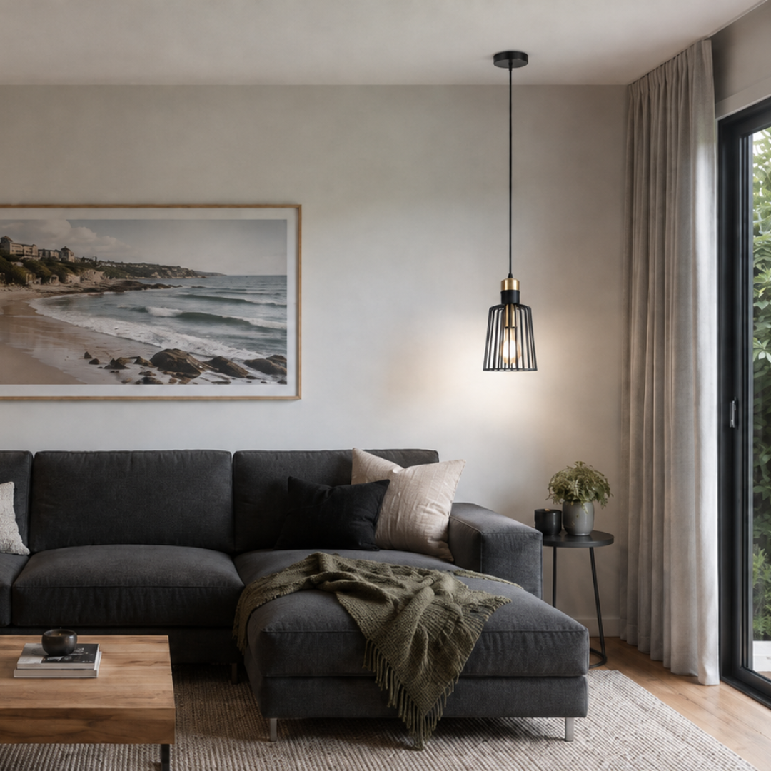 A modern living room featuring a dark gray sectional sofa, a wooden coffee table, and a large framed landscape photograph of a beach coastline hanging on the wall above the sofa.